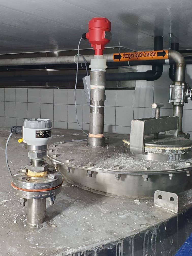 A flange-mounted radar level sensor installed on top of a process tank — radar level measurement in the field