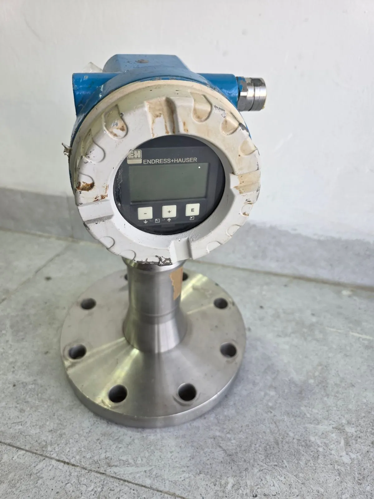 Front view of the Micropilot M FMR245 radar transmitter with four-line display on a stainless-steel flange