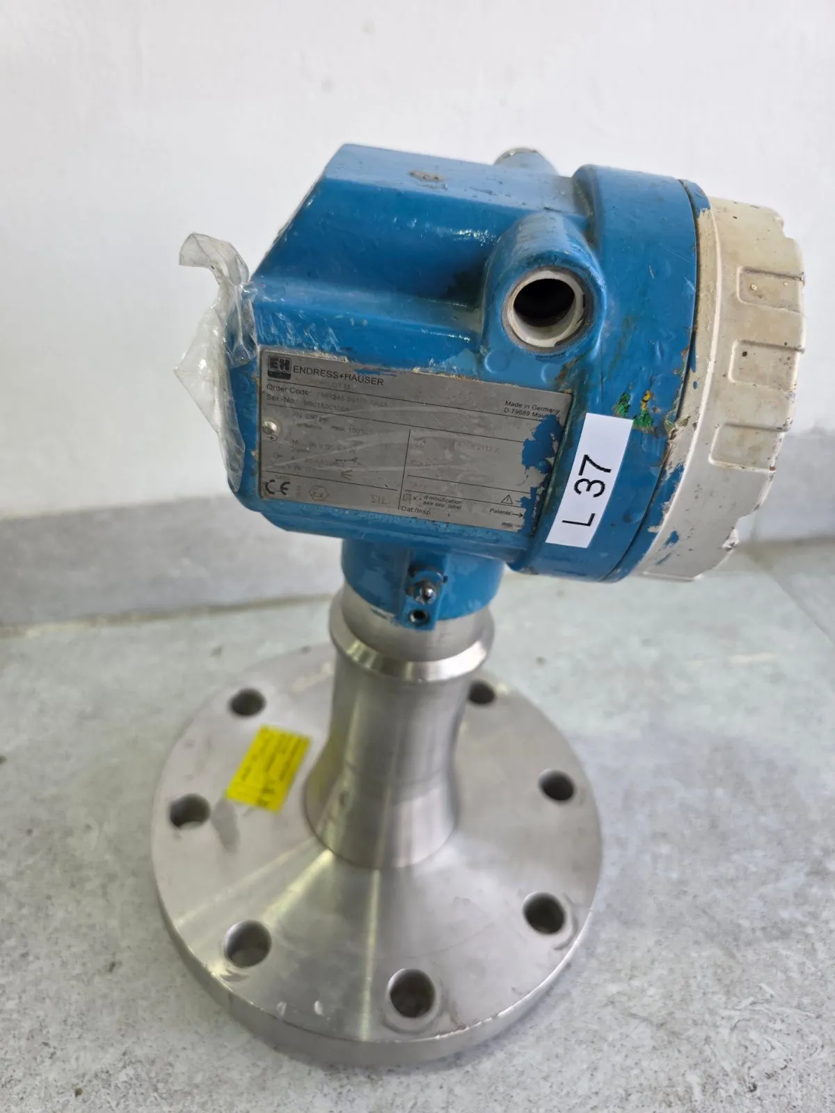 Angled view of the blue housing and stainless-steel flange of the FMR245