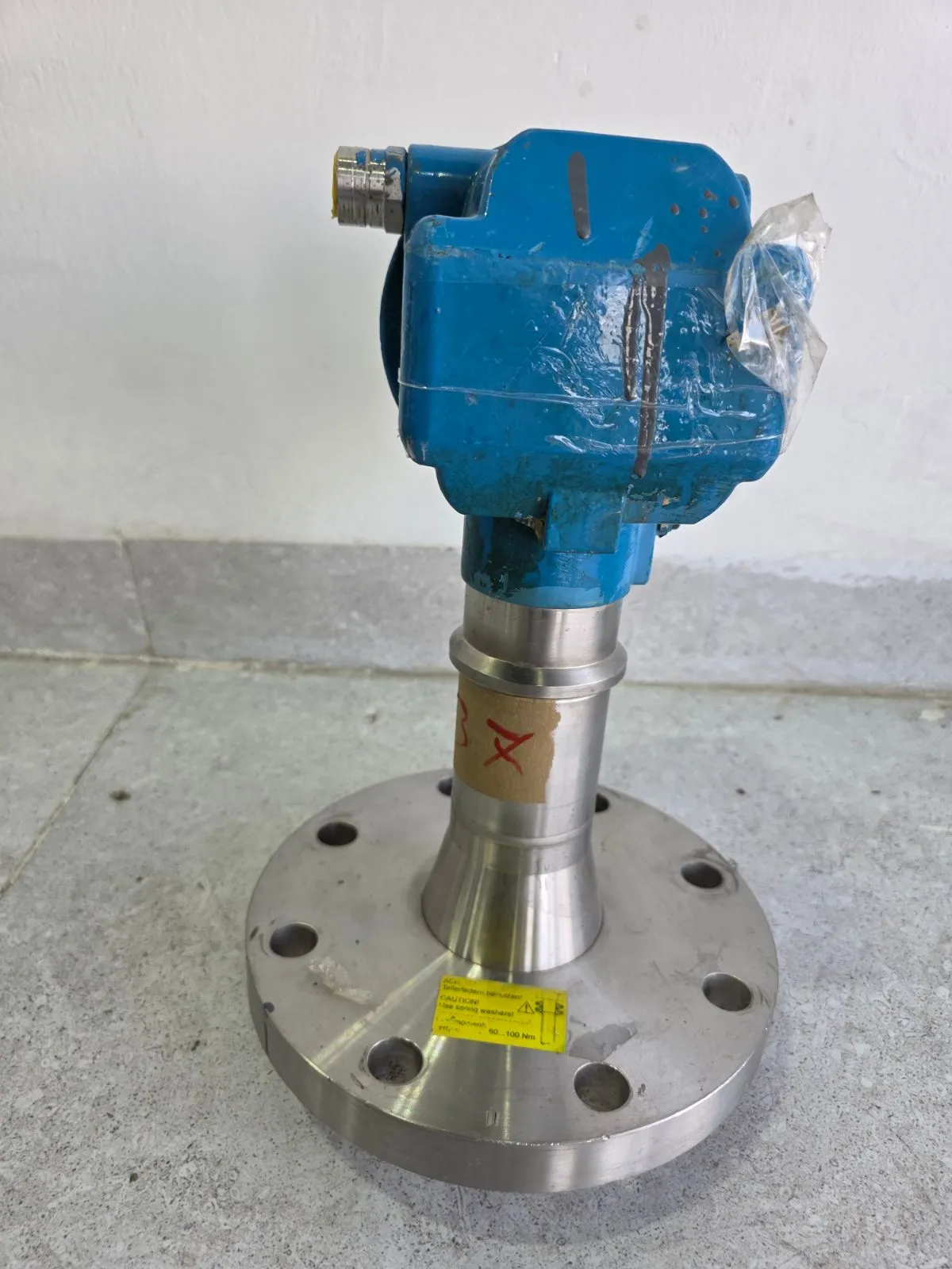 Side view of the FMR245 on its stainless-steel flange showing the cable entry and PTFE-clad antenna
