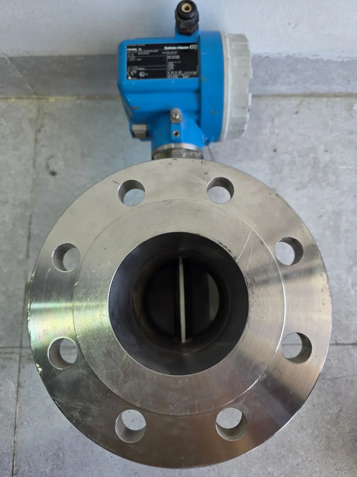 Axial view into the flange bore showing the vortex-shedding bluff body across the eight-bolt flange