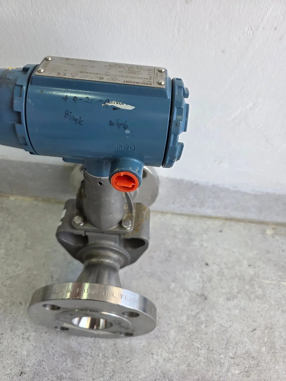 Angled view of the blue Rosemount transmitter head with M20 cable entry and reducer body with a 316/316L stainless-steel flange