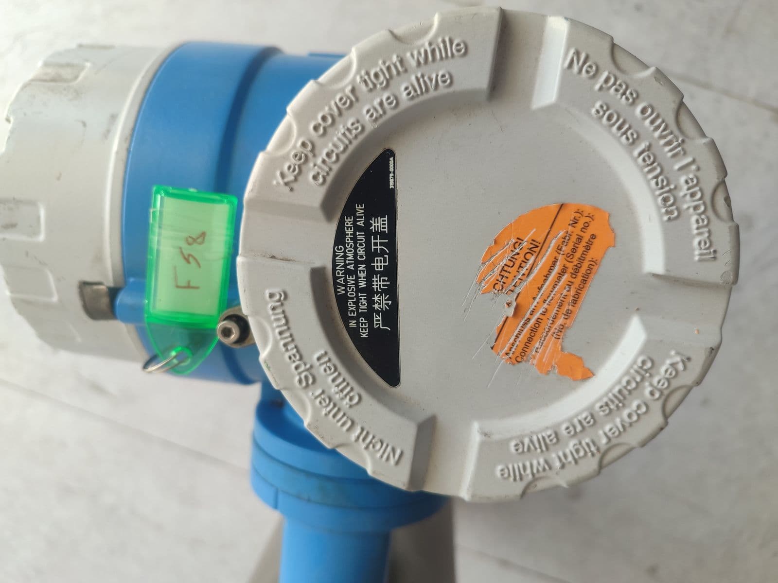 Endress+Hauser Promass 83F Coriolis mass flowmeter — transmitter cover of unit 4 in Barmaan's warehouse; the sensor-pairing sticker has been scratched out