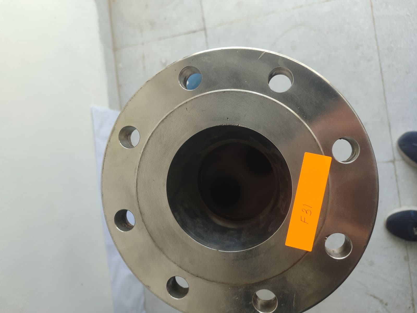 Flange face of the oldest meter seen from above — eight bolt holes and the raised face of a 4″ ASME Class 150 flange bored for 3″ pipe